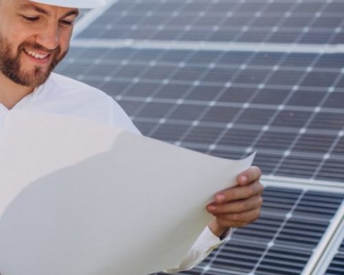 Young architect standing by solar panels